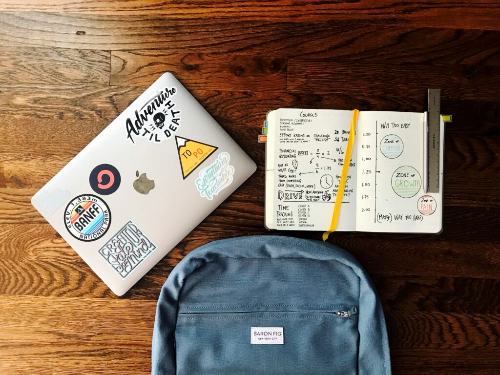 desk with laptop, backpack, and college book